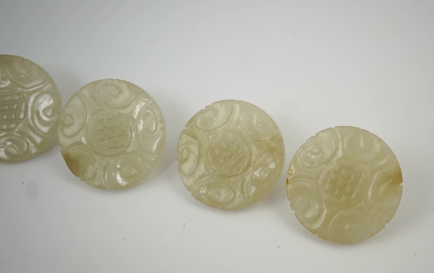 A set of five Chinese pale celadon jade robe buttons, 19th century